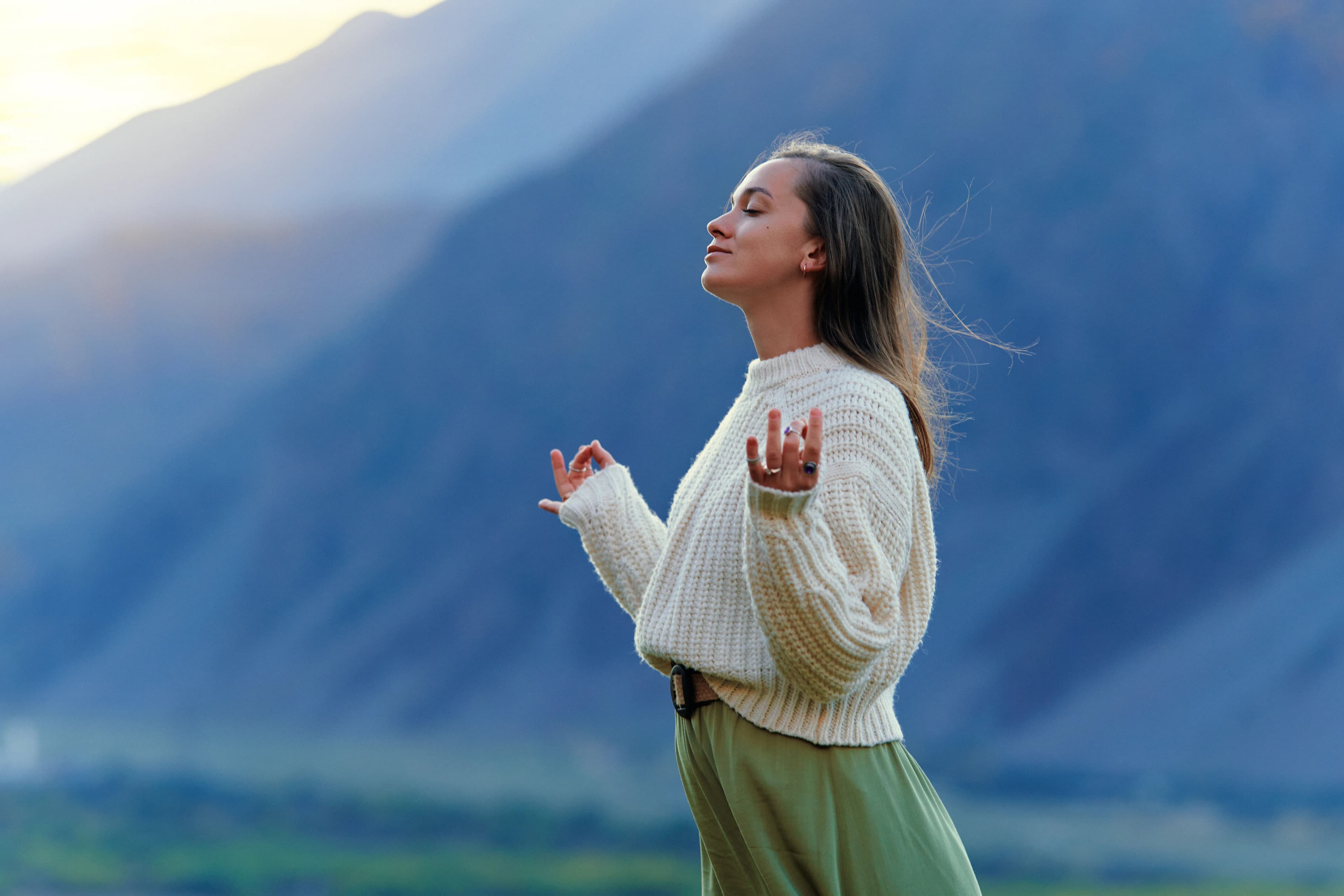 Serene, peaceful, tranquil woman with hands in lotus pose, closed eyes, standing alone, enjoying freedom and calm mind